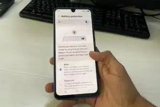 Hand holding smartphone displaying battery protection menu when fast charging stops at 80%