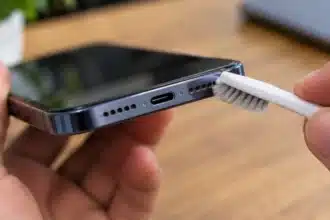 Cleaning a phone speaker grille with a soft brush to remove dust