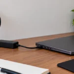 Closed laptop plugged into a charger on a desk