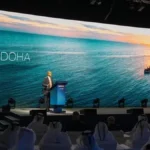 MWC26 Doha conference stage with a speaker and MWC Doha branding on a large screen